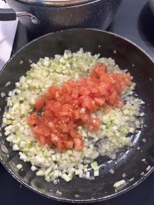 onions, courgette and tomatoes in a pan