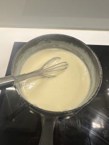 adding milk to form bechamel sauce