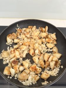 Adding boiled potatoes to softened onion for Spanish tortilla base