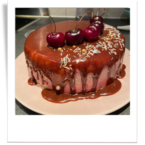 Almond sponge cake layered with cherry mousse and topped with a rich chocolate glaze and fresh cherries