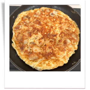 spanish tortilla cooked, stil in a pan, nice and golden brown