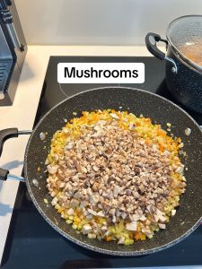 adding the mushrooms to the sauce